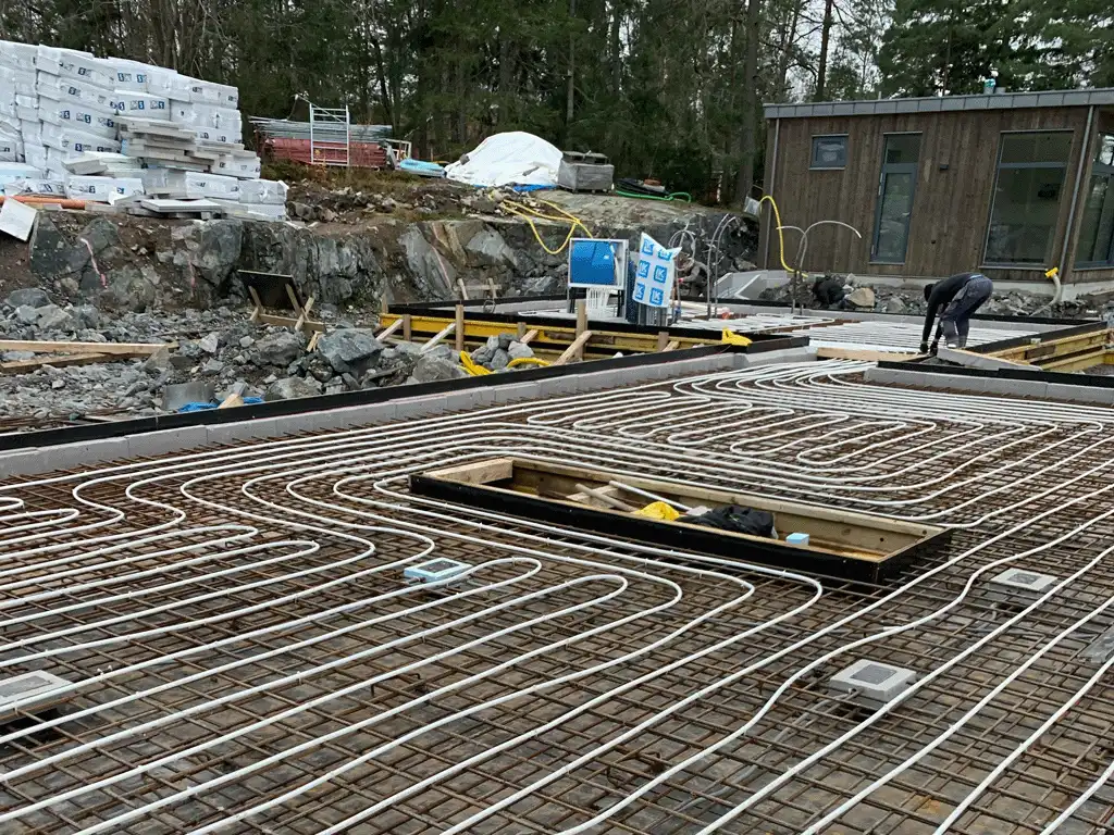 Fotot visar husets grund med armering utlagd, golvvärme och all rörmokeri redo för betonggjutning i Täby, Stockholm. Fotot visar husets grund med armering utlagd, golvvärme och all rörmokeri redo för betonggjutning i Täby, Stockholm.
