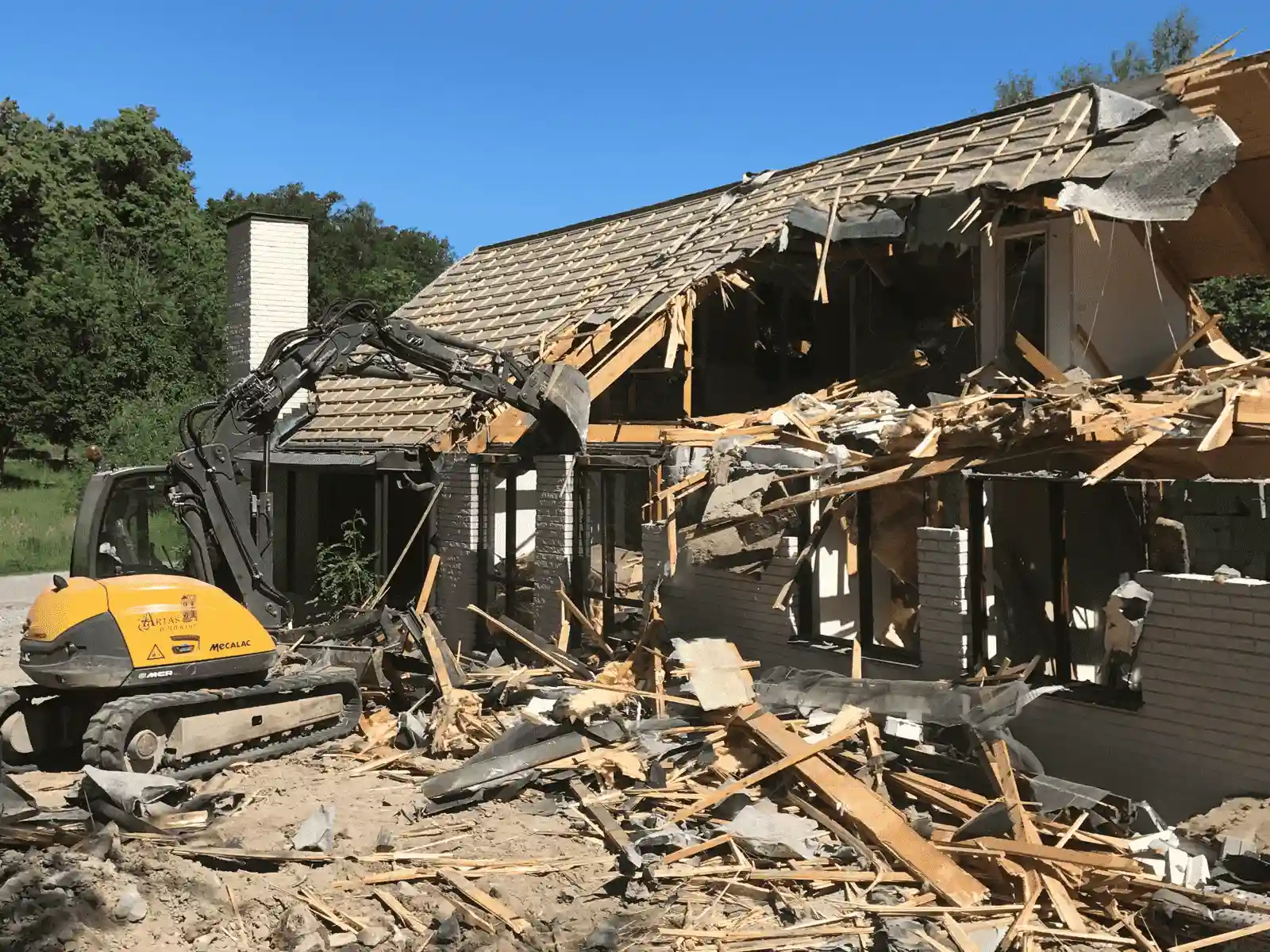 en grävmaskin river ett tak i Stockholm vid rivningen av ett hus en grävmaskin river ett tak i Stockholm vid rivningen av ett hus